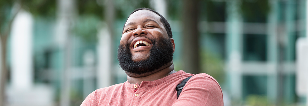 Man outside laughing.